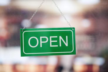 Female Owner Holding Closed Sign