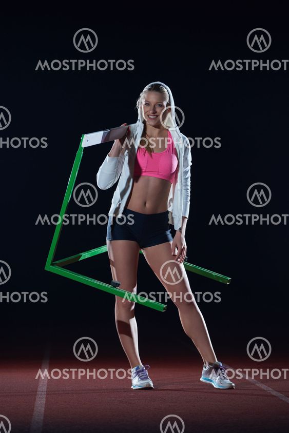 woman athlete jumping over a hurdles