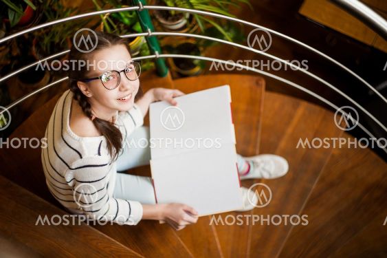The girl in glasses with a book in their hands