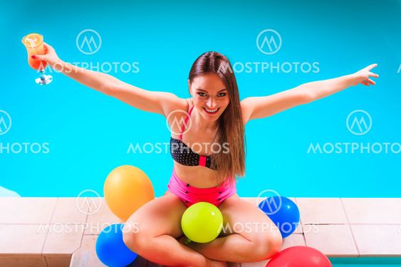 Happy woman with balloons and cocktail.