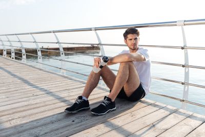 Tired young sportsman sitting and relaxing