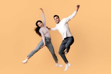 Playful Mood. Happy Middle Eastern Couple Jumping In Air...