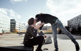 Couple kissing while standing on skateboards