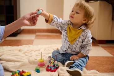 Young Toddler Playing Indoors with Educational Toys...