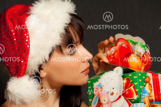 Girl in a santas cap opens the surprise