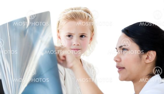 Attentive female doctor showing an x-ray to a little girl