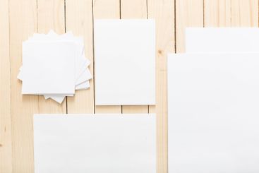 Assorted sheets of blank paper arranged on a wooden...