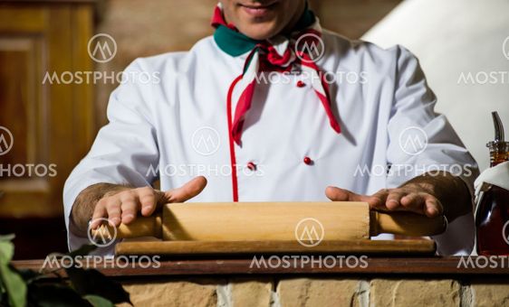 Cook rolls out the dough on a board