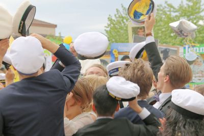 Happy teenagers raising the graduation cap celebrating...