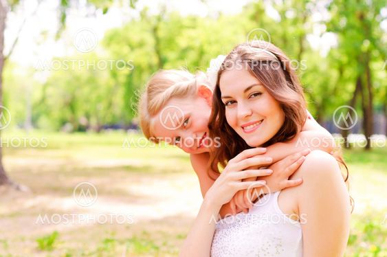 mother and daughter sitting together on the grass