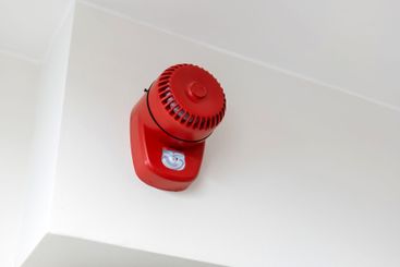 Red fire alarm system speaker buzzer installed on white...