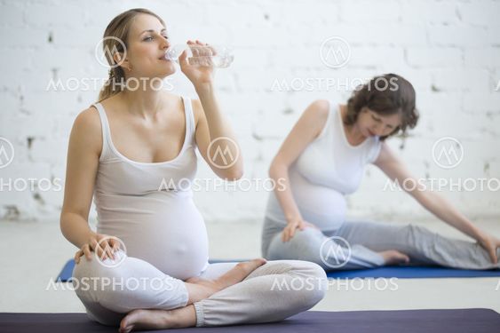 Pregnant women getting ready for exercising in fitness class