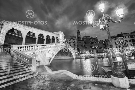 VENICE, ITALY - MAR 23, 2014: Rialto Bridge at sunset with tourists. The city has 21 million visitors each year