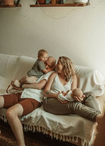 Parents, kids and a family joking on the sofa in the...