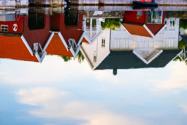 traditional scandinavian houses reflected in water.