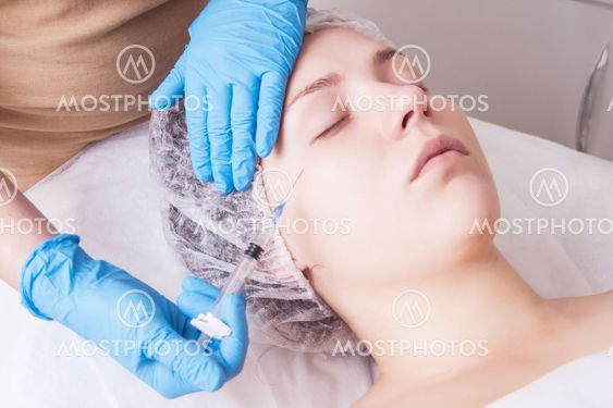Hands of cosmetologist are close-ups that inject...