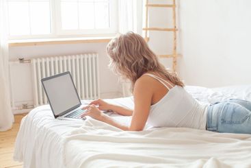 Blonde woman using laptop computer at home