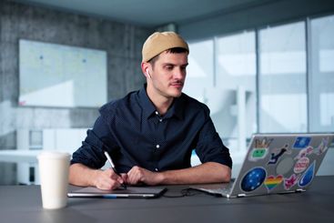 Happy Young Male Designer Using Laptop