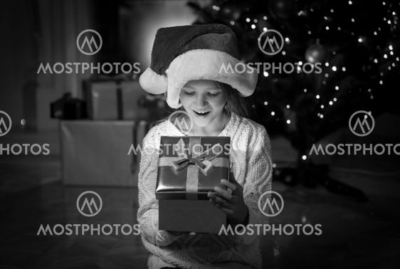 portrait of happy amazed girl looking inside of Christmas...