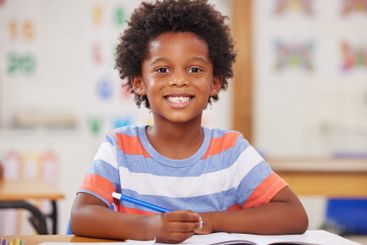 Education, portrait and writing of boy student in...