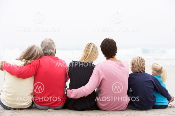 Back View Of Three Generation Family Sitting On Winter...