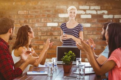 Composite image of colleagues clapping hands in a meeting