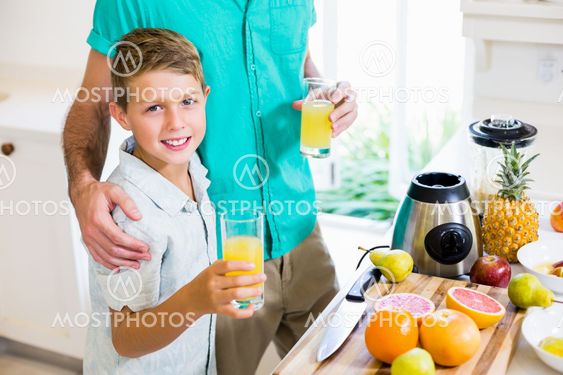 Father and son holding glass of a juice
