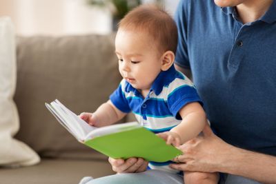 baby boy and father with book at home
