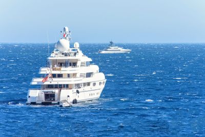 Daylight close-up view to white yachts with people on board