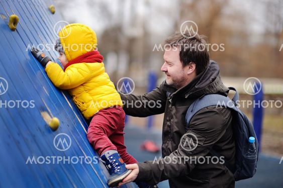 Happy little boy with his father having fun on outdoor...