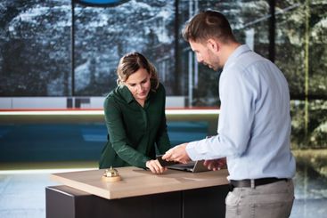 Man At Hotel Talking To Receptionist Woman
