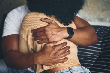 Closeup, couple and hugging on sofa for support with...