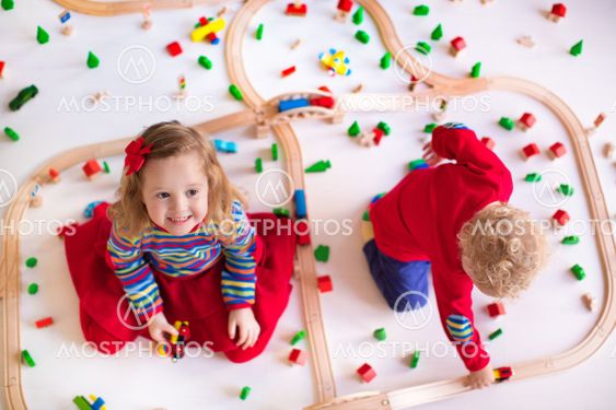 Kids playing with wooden train set