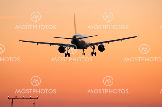 Airliner landing at sunset