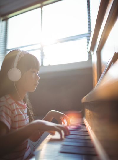 Concentrated girl looking at digital tablet while...