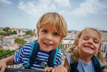 Happy portrait of two kids travelers at Lisbon viewpoint