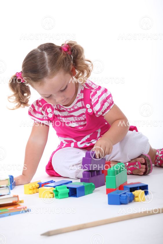 Little girl playing with building blocks