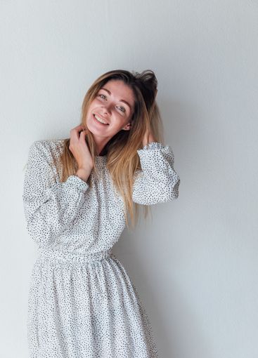 Beautiful woman in summer dress smiling on white background