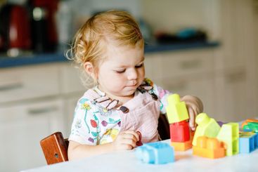 Adorable toddler girl with educational toys in nursery...