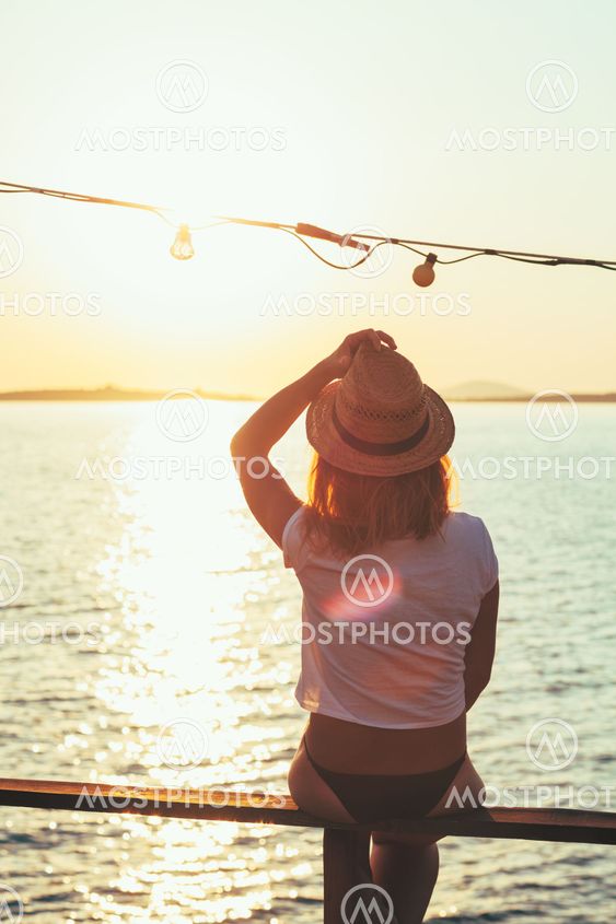 Young woman enjoying sunset at a beach bar
