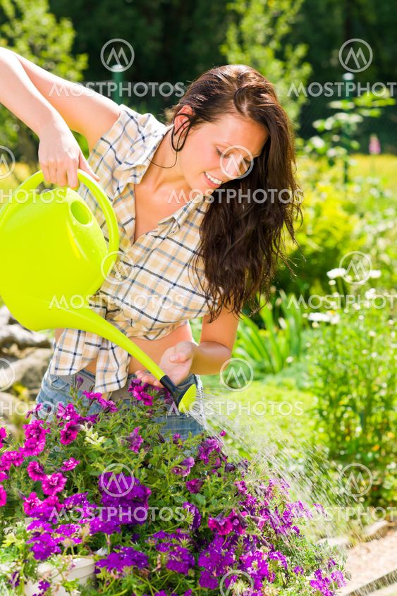 Gardening smiling woman watering can violet flower