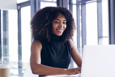 Office, typing and African business woman on laptop for...
