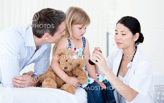 Confident asian female doctor giving syrup to a little girl
