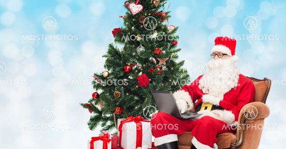 man in costume of santa claus with laptop