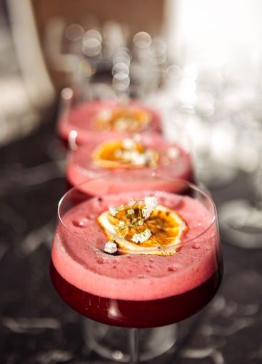 Pink sweet and sour berry cocktails with fluffy foam in...