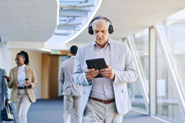 Business man, headphones and technology, walking and...