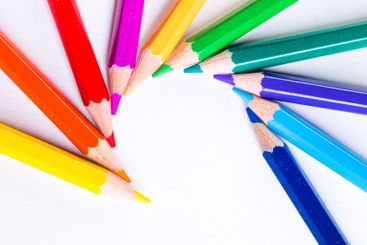 Colorful pencils arranged in a circular pattern on a...