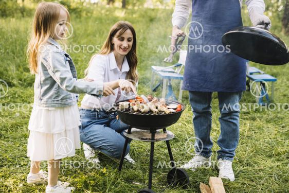 family doing barbecue nature. High quality beautiful...