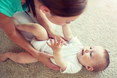 happy mother playing with baby at home