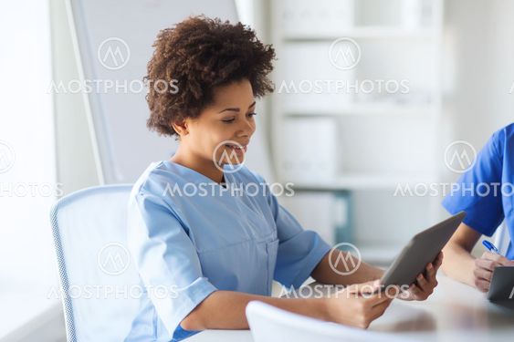 happy female doctor or nurse with tablet pc